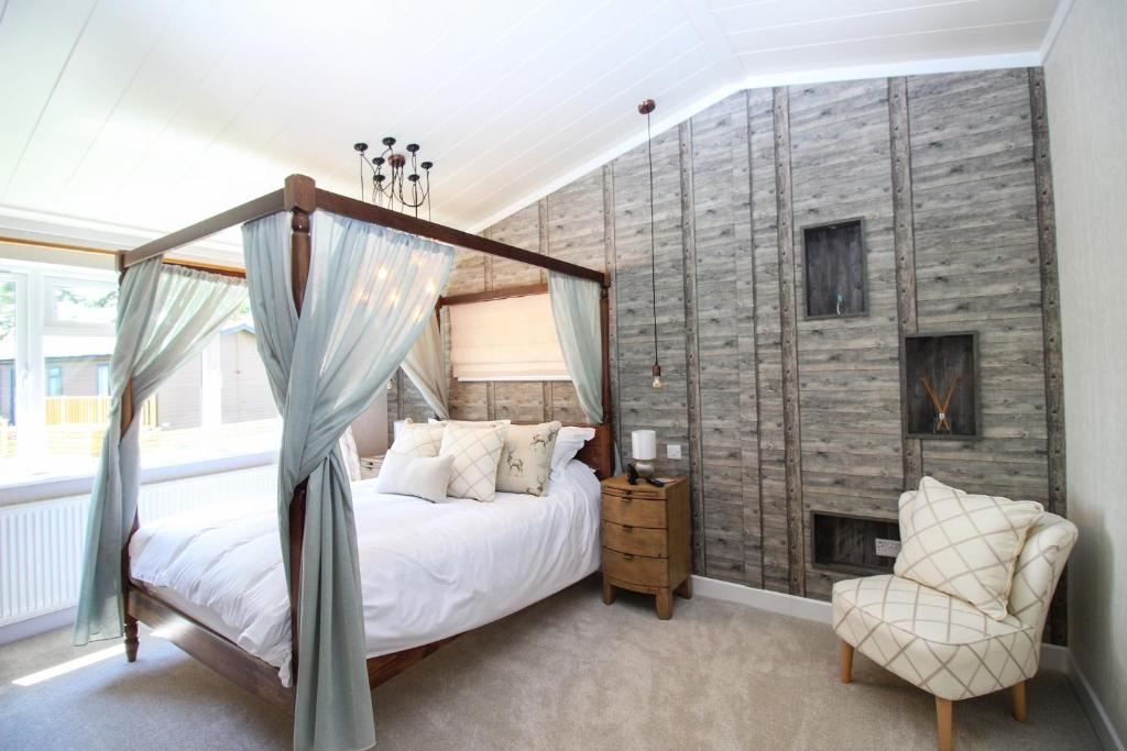 约克Hollicarrs - Kingfisher Lodge的一间卧室设有一张天蓬床和一个壁炉