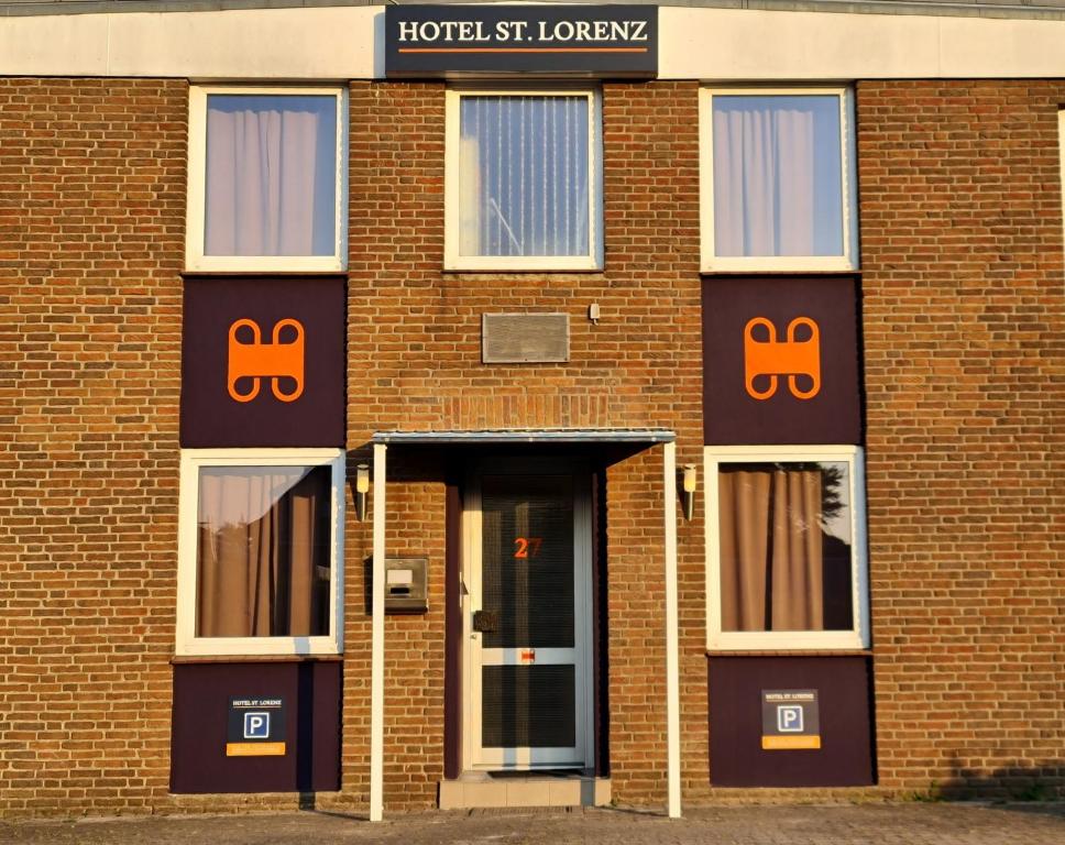 吕贝克Hotel Sankt Lorenz的一座砖砌的建筑,上面有橙色的标志