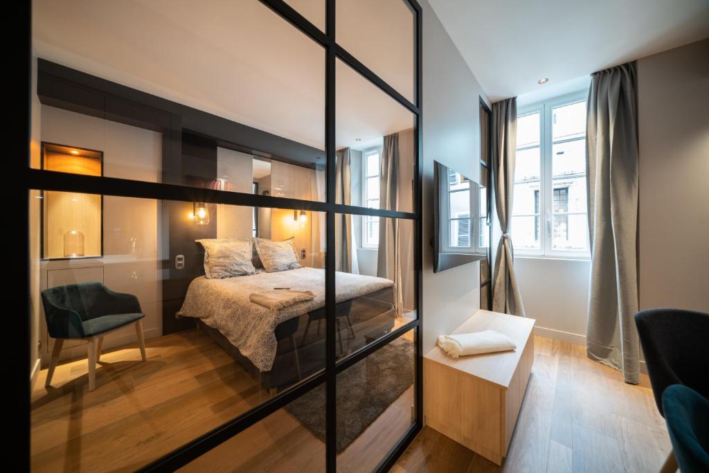 安锡Le Luxury Design de la Vieille Ville的一间卧室设有一张床和玻璃墙