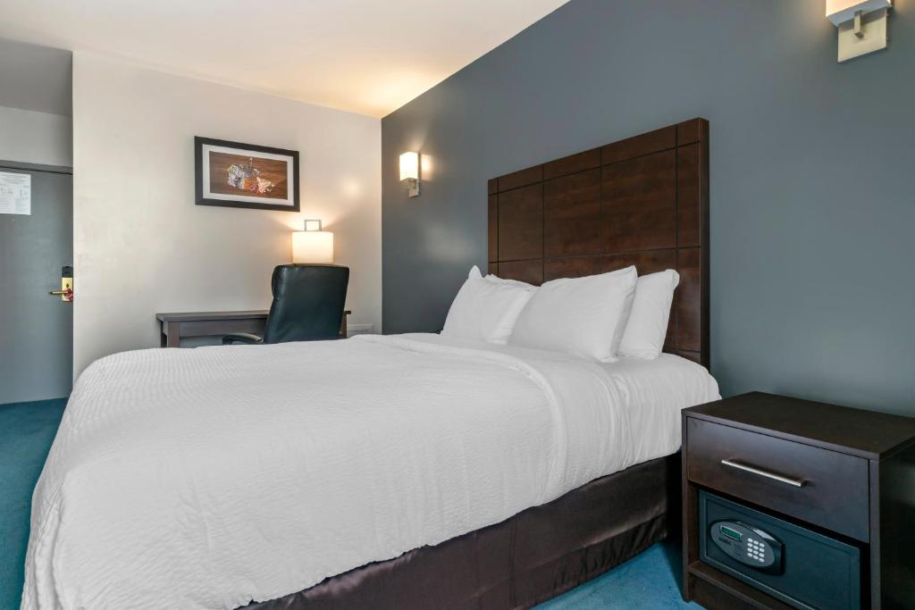 蒙特利尔Econo Lodge的酒店客房带一张大床和一把椅子
