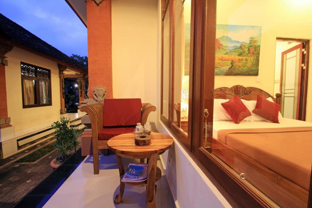 乌布KT夸雅斯民宿酒店的卧室配有1张床、1张桌子和1把椅子