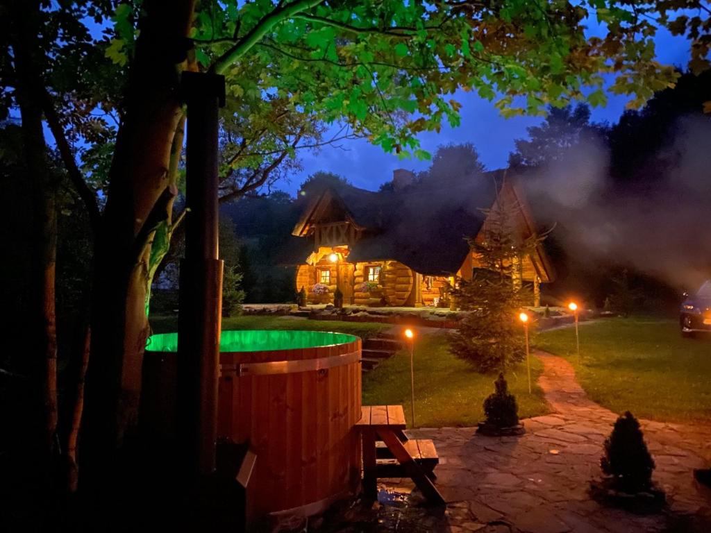 ChyrowaDomek Szyjówka的小木屋,晚上设有绿色游泳池