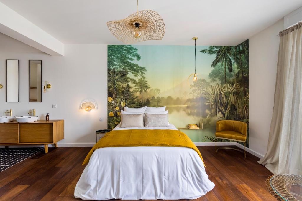 巴约讷Libertitu的卧室配有一张床,墙上挂有绘画作品
