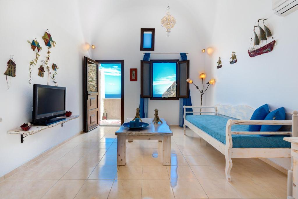 卡马利Moschatos Beach House的一间卧室配有一张床、一台电视和一张桌子