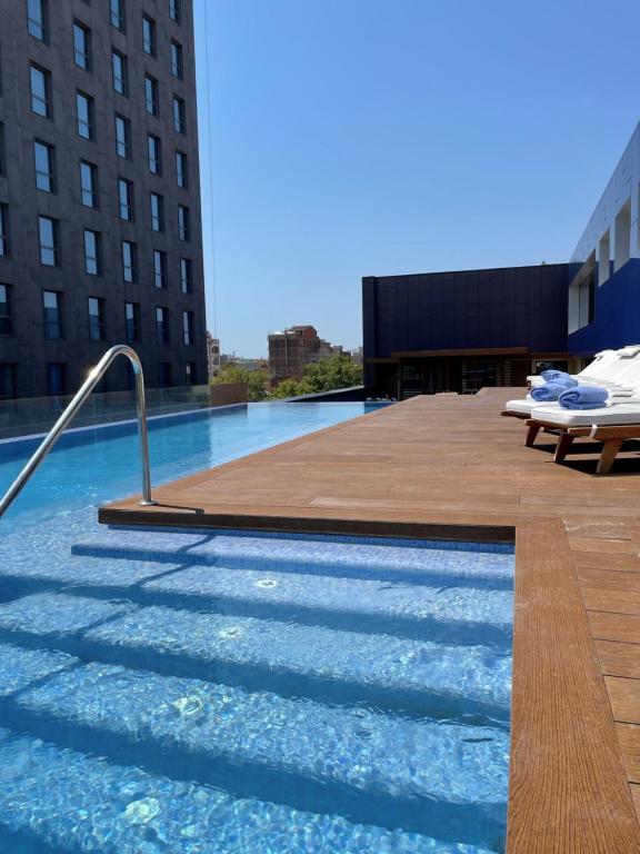 巴塞罗那Hotel Paxton Barcelona的建筑物屋顶上的游泳池