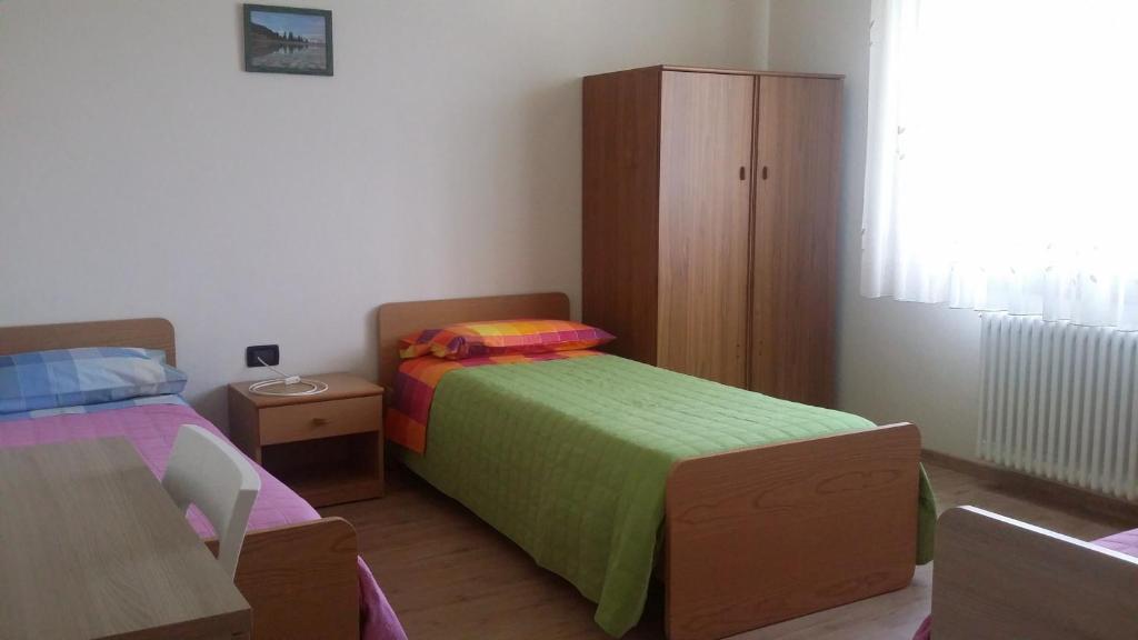 卡尔切拉尼卡阿拉戈Casa Ferrari Michela的一间卧室设有两张床和木制橱柜