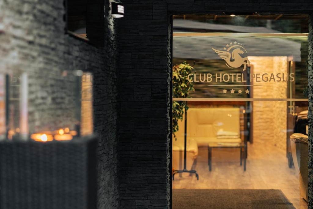 TiszaugClub Hotel Pegasus的通往俱乐部酒店的门,窗户上设有桌子