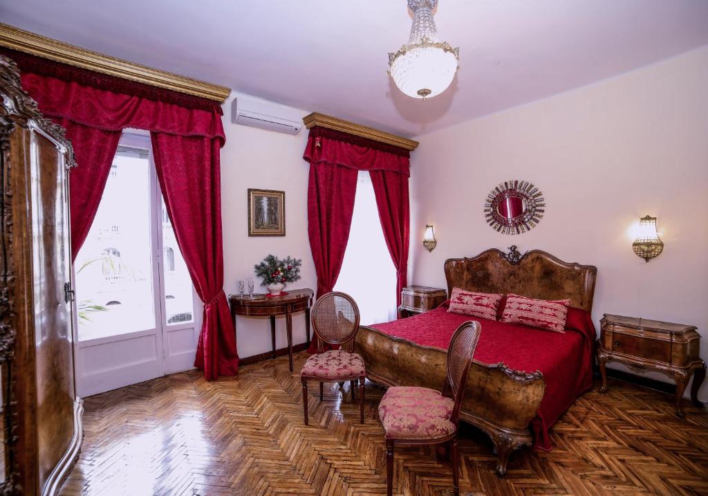 那不勒斯WELL COME - Palazzo Reale的一间卧室配有红色床单和红色窗帘