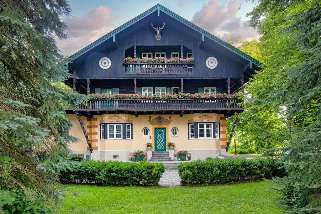 蒂克海姆Villa Zollhaus Bed & Breakfast的一座带绿门和阳台的房子