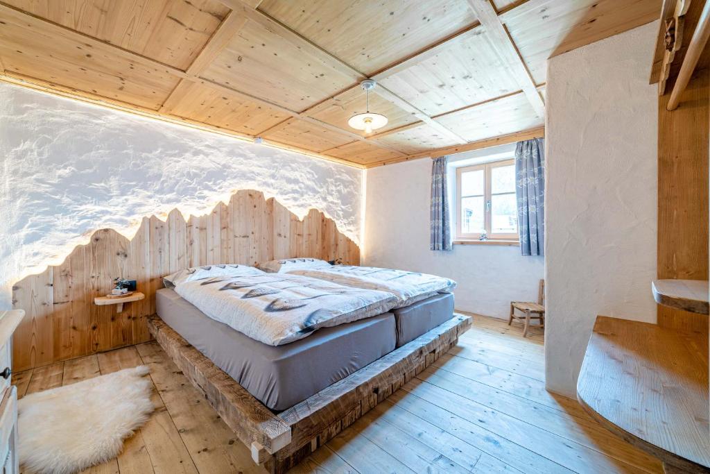 Colle Santa LuciaOspitalità Diffusa Laste Dolomites - Cèsa del Bepo Moro的一间卧室设有一张带木制天花板的大床