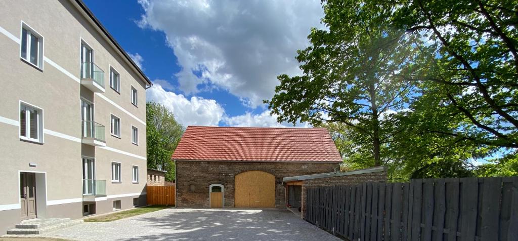 柯尼希斯武斯特豪森Ferienwohnung Carla Rohls的砖砌建筑,有红屋顶,靠近栅栏