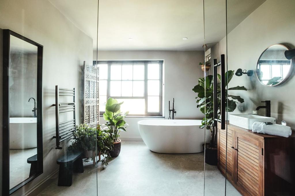 拉伊The fig的浴室配有大浴缸和植物