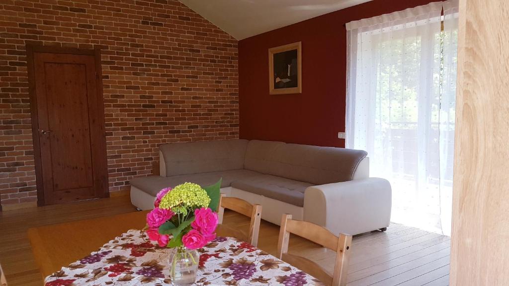 拉脱维亚Cozy Corner的客厅配有沙发和鲜花桌