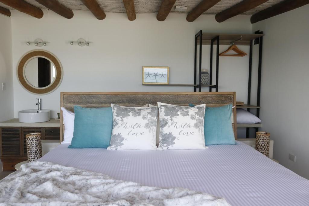 PampatarAria By LD Hotel Boutique的一间卧室配有一张带蓝色和白色枕头的床