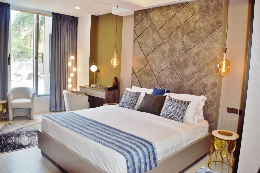阿克拉THE POOL LABONE的酒店客房设有一张大床和一张书桌。