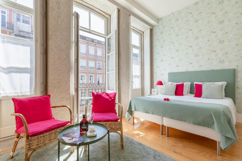 波尔图Inside Porto Apartments - Mouzinho的一间卧室配有一张床、两把椅子和一张桌子