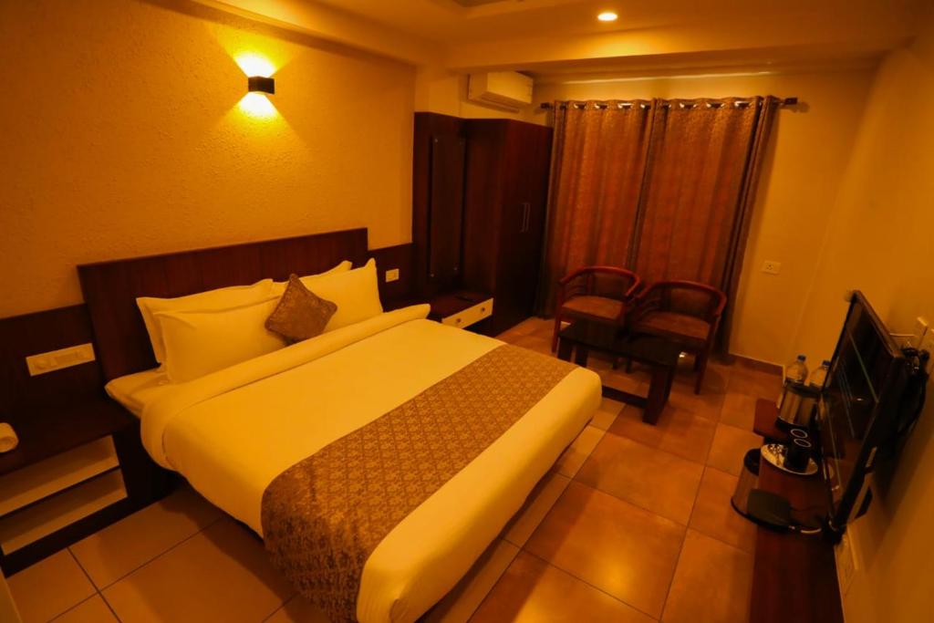 卡尔佩特塔Zubis Inn Hotel的配有一张床和一把椅子的酒店客房