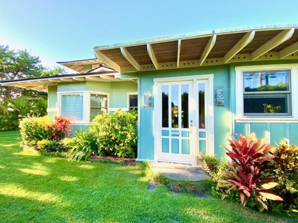 凯卢阿Modern Luxury Beach House Kailua的一座带蓝色门和庭院的绿色房子