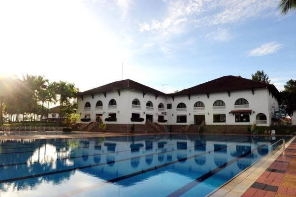 新山庞德尔罗萨高尔夫乡村度假酒店的一座大型白色建筑,设有大型游泳池