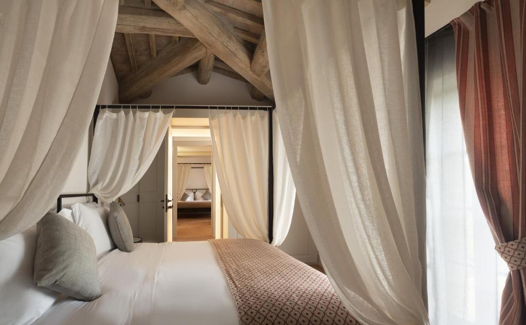 蒙塔尔奇诺Tenuta CastelGiocondo的一间卧室配有一张带窗帘的大床