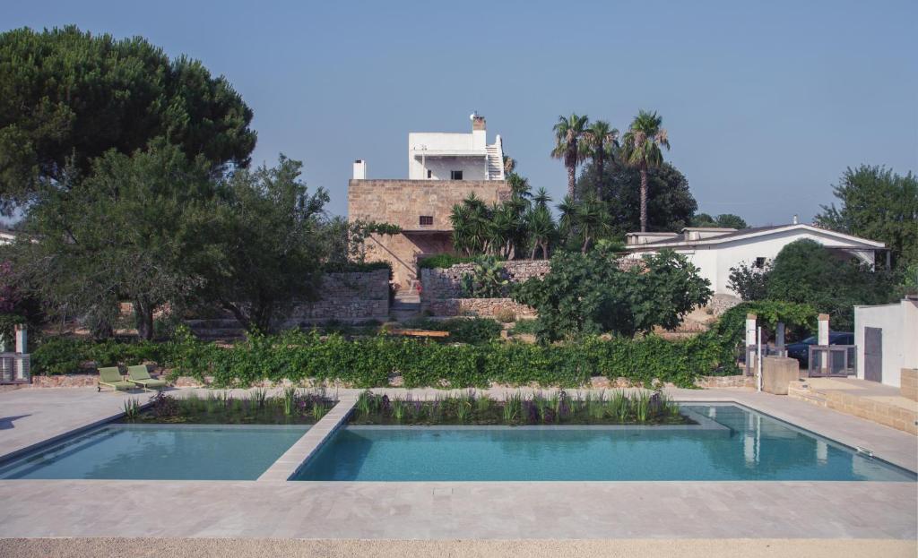 乌真托Agriturismo Masseria Gianferrante的房屋前的游泳池