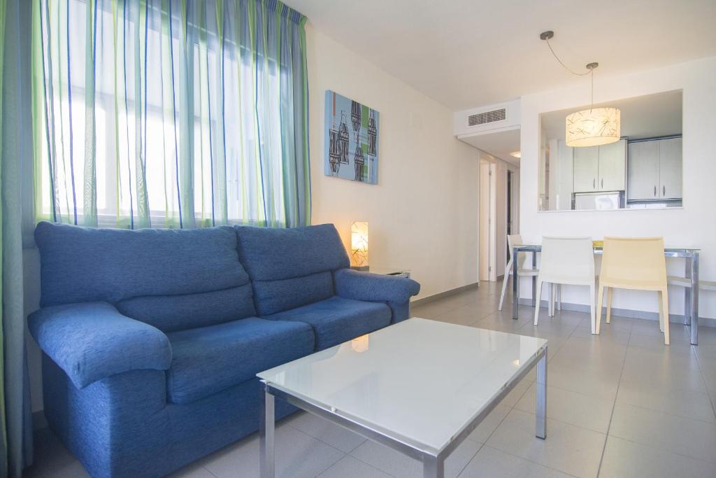 卡尔佩海泊凯姆普斯卡尔佩公寓酒店的客厅配有蓝色的沙发和桌子