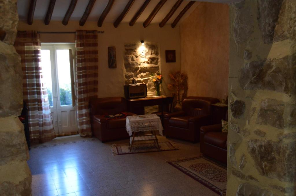 RaffoCasa "Albero Verde"的客厅配有皮革家具和石墙