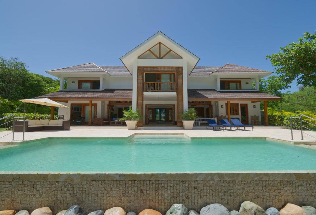 蓬塔卡纳Amazing 4-bedroom tropical villa with private pool and golf course view at luxury resort的房屋前有游泳池的房子
