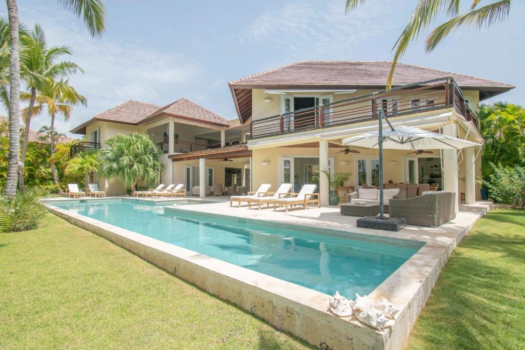 蓬塔卡纳Spacious lake front villa with in-room jacuzzis in luxury golf and beach resort的房屋前有游泳池的房子