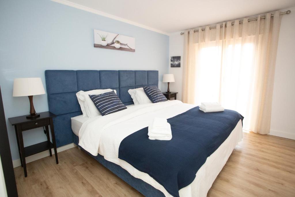 AgualvaMeriteluna Pateo - Entre Lisboa, Sintra e Cascais的蓝色和白色的卧室设有一张大床
