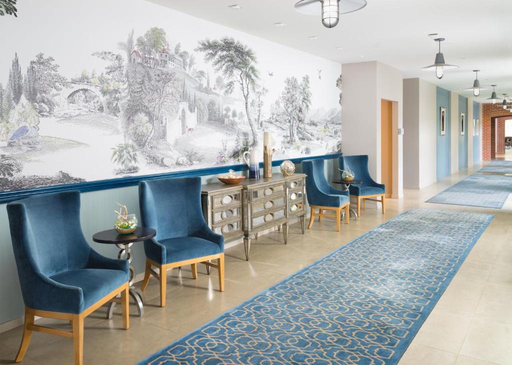 亚历山德里亚亚历山德里亚老城英迪格酒店的走廊上设有蓝色椅子和壁画