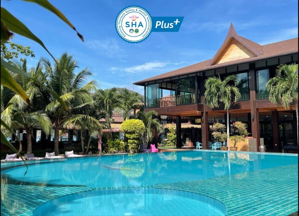 皮皮岛Phi Phi Villa Resort-SHA Extra Plus的一座带大型游泳池的度假村,位于一座建筑前