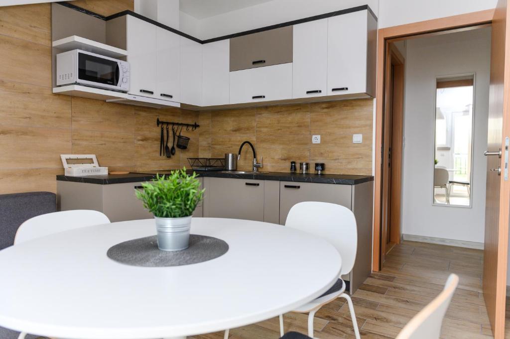 索科矿泉村Panorama Lux的厨房以及带白色桌椅的用餐室。