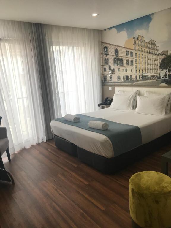里斯本芬尼舍斯魅力酒店的卧室配有带白色枕头的大床