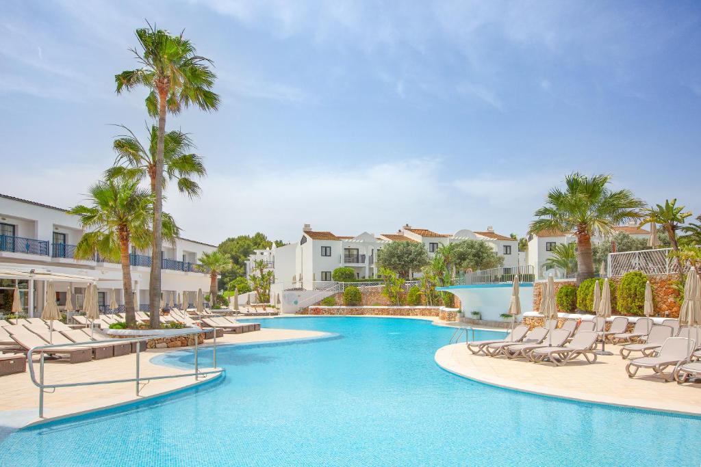 卡兰博希MarSenses Paradise Club的度假村内一个带躺椅和棕榈树的游泳池