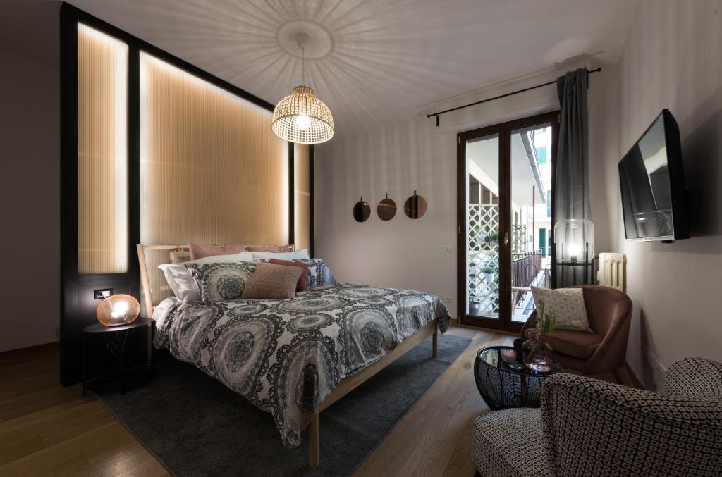 佛罗伦萨B&B La Marmora 39的一间卧室配有一张床、一台电视和一张沙发