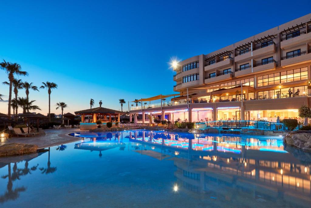帕福斯Atlantica Golden Beach Hotel - Adults Only的大楼前有游泳池的酒店