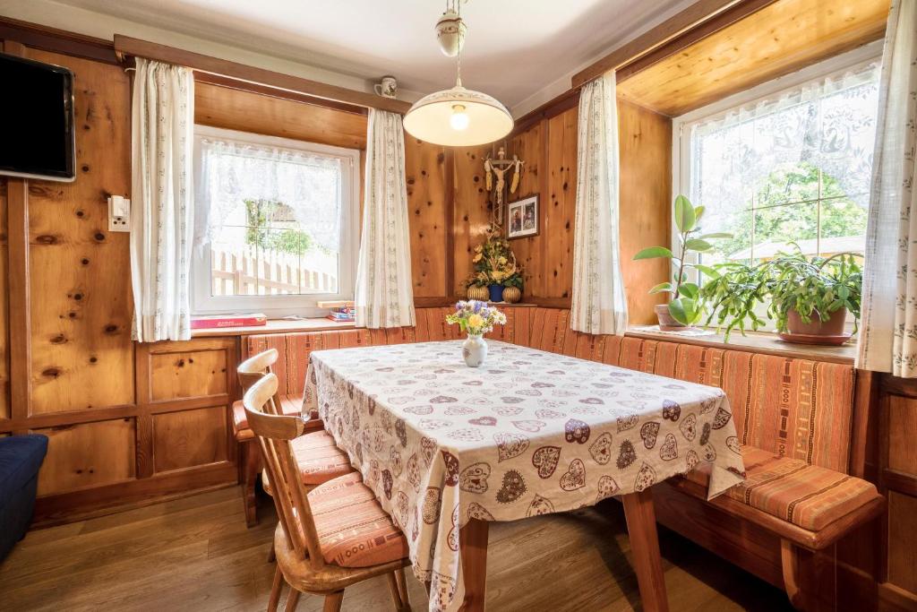 马兰扎Haus Adler的一间带桌子和2个窗户的用餐室