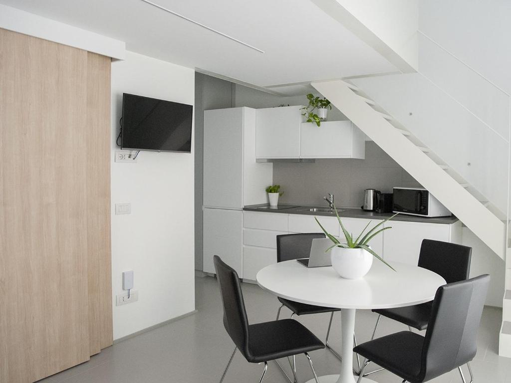 米兰Brand new apartments Ortiquattro的白色的用餐室配有白色的桌椅