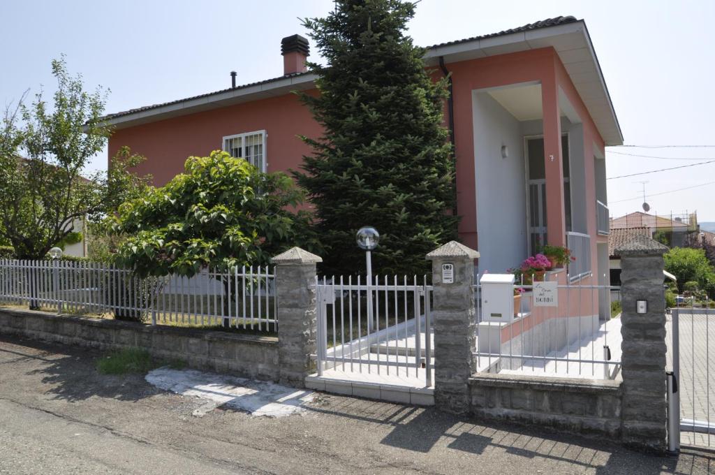 Felegara戴诺尼住宿加早餐旅馆的粉红色房子前面的白色围栏