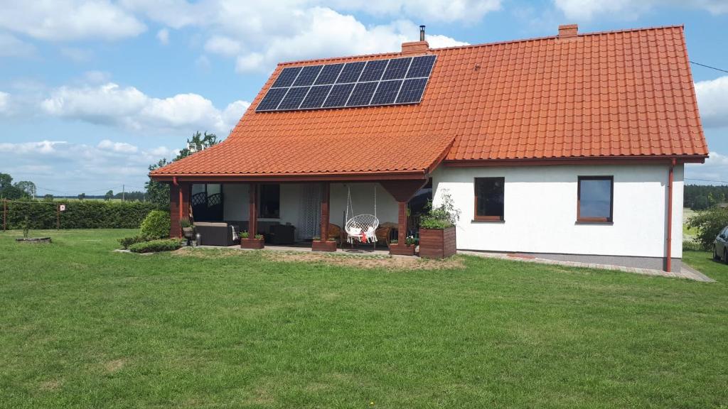 DziałekRanczo的屋顶上设有太阳能电池板的白色房子