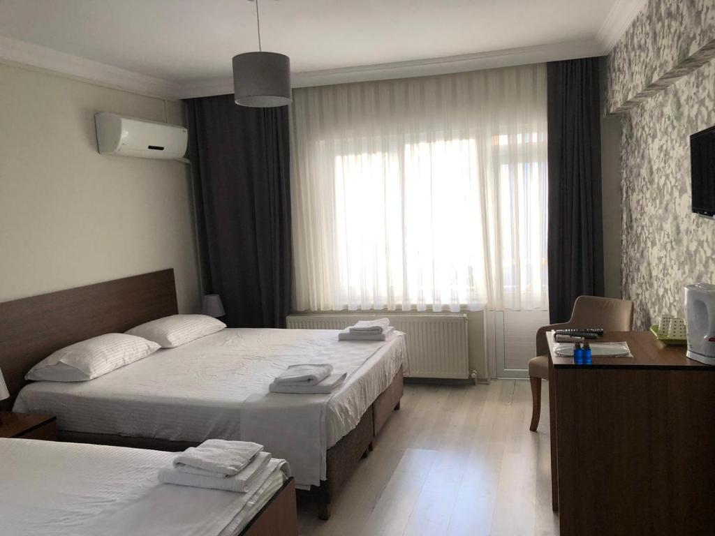 巴勒克埃西尔Özdemir Otel的酒店客房设有两张床和窗户。