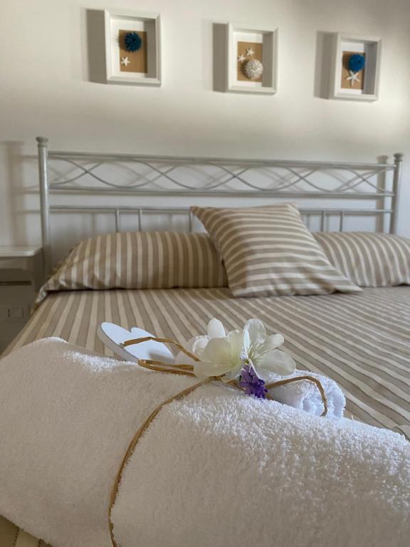 马鲁焦Pinulà的一张带白色毛巾的床,上面有花
