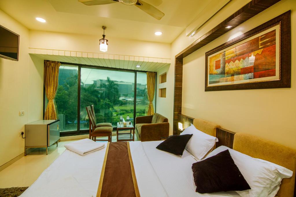 孟买La Hotel Metro near BKC的一间卧室设有一张床和一个美景窗户。