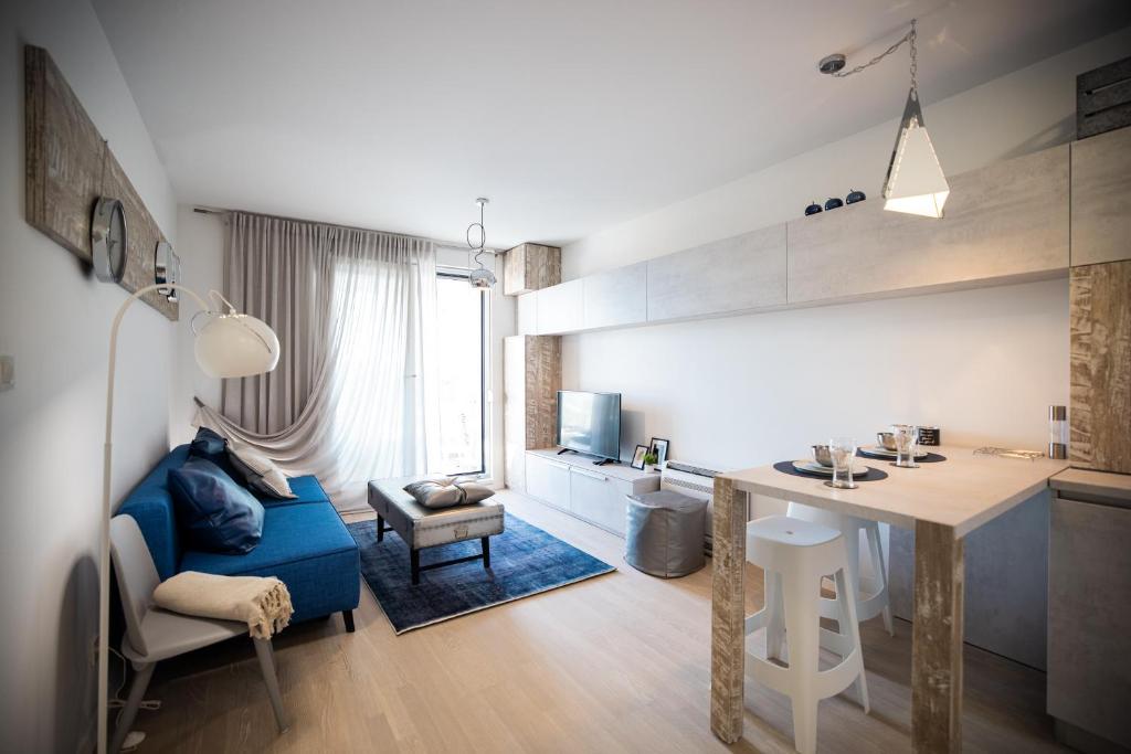 扎达尔Island View Luxury Apartments的厨房以及带蓝色沙发和桌子的客厅。