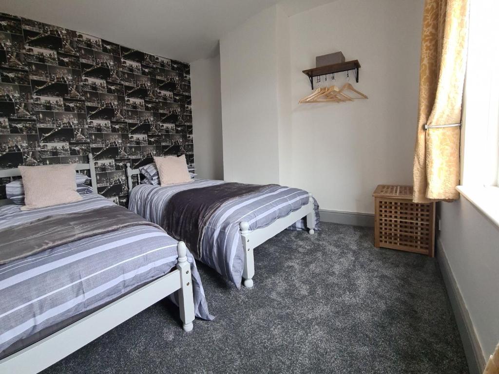 Pelton1 Grange Street的一间卧室设有两张床和一张带照片的墙壁