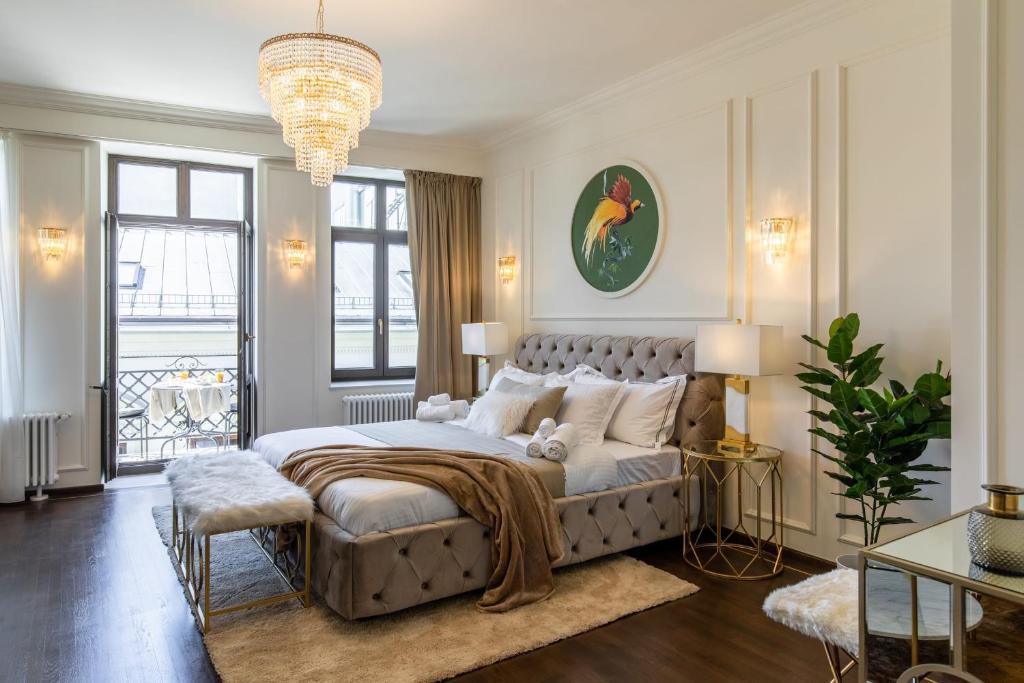 布加勒斯特HOLT Old Town Suites with Balcony的一间卧室配有一张大床和一个吊灯。