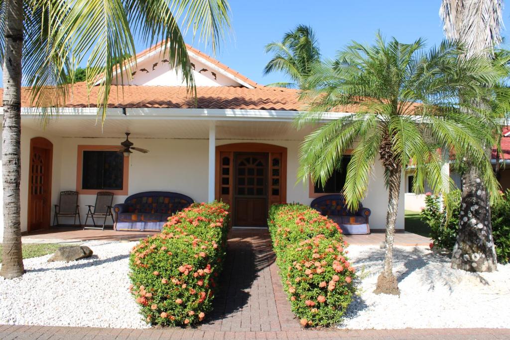 帕克拉Villa Serenidad的两棵棕榈树和门廊的房子