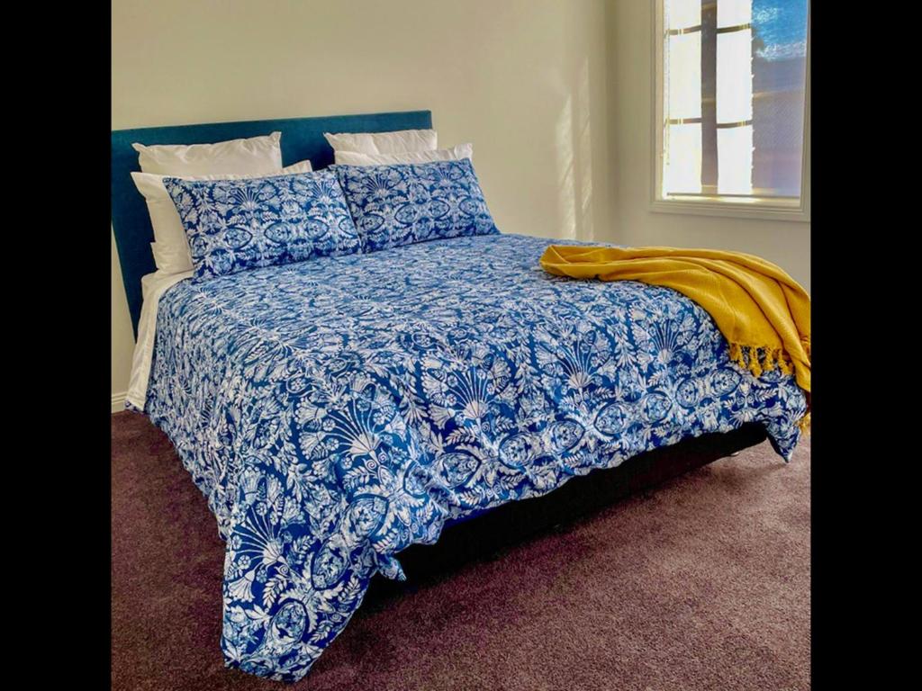 巴拉腊特Ballarat CBD Accommodation 2 Bd Townhouse Talbot Terrace的一张带蓝色和白色棉被和枕头的床