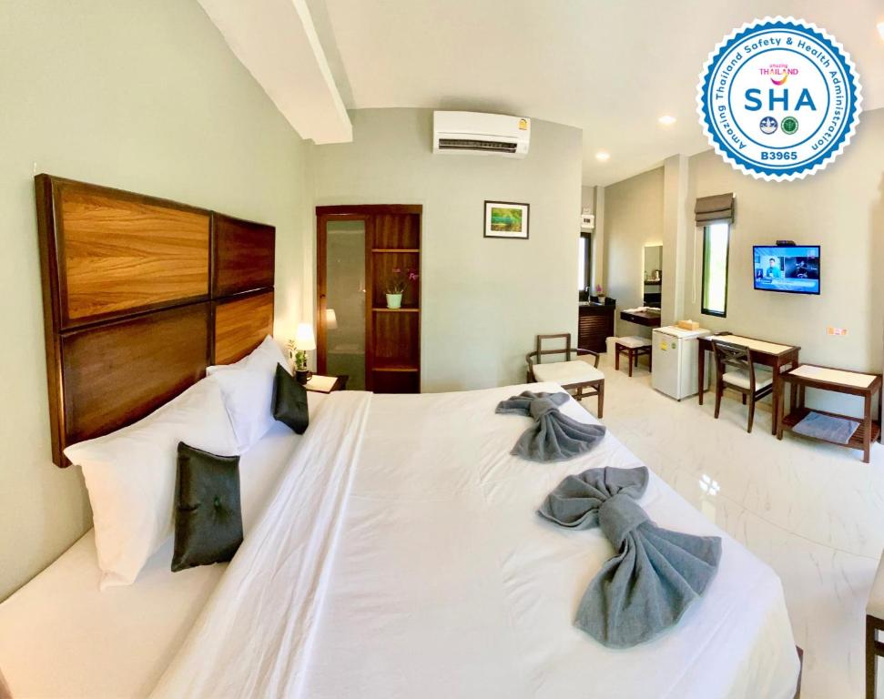 Takua PaPalm Scenery Resort的卧室配有一张带两个弓形枕头的大型白色床。